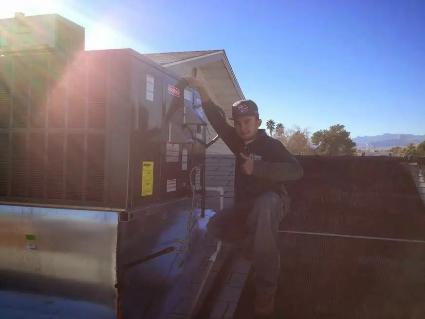 HVAC technician performing AC Tune-Up on a rooftop unit in Vancouver